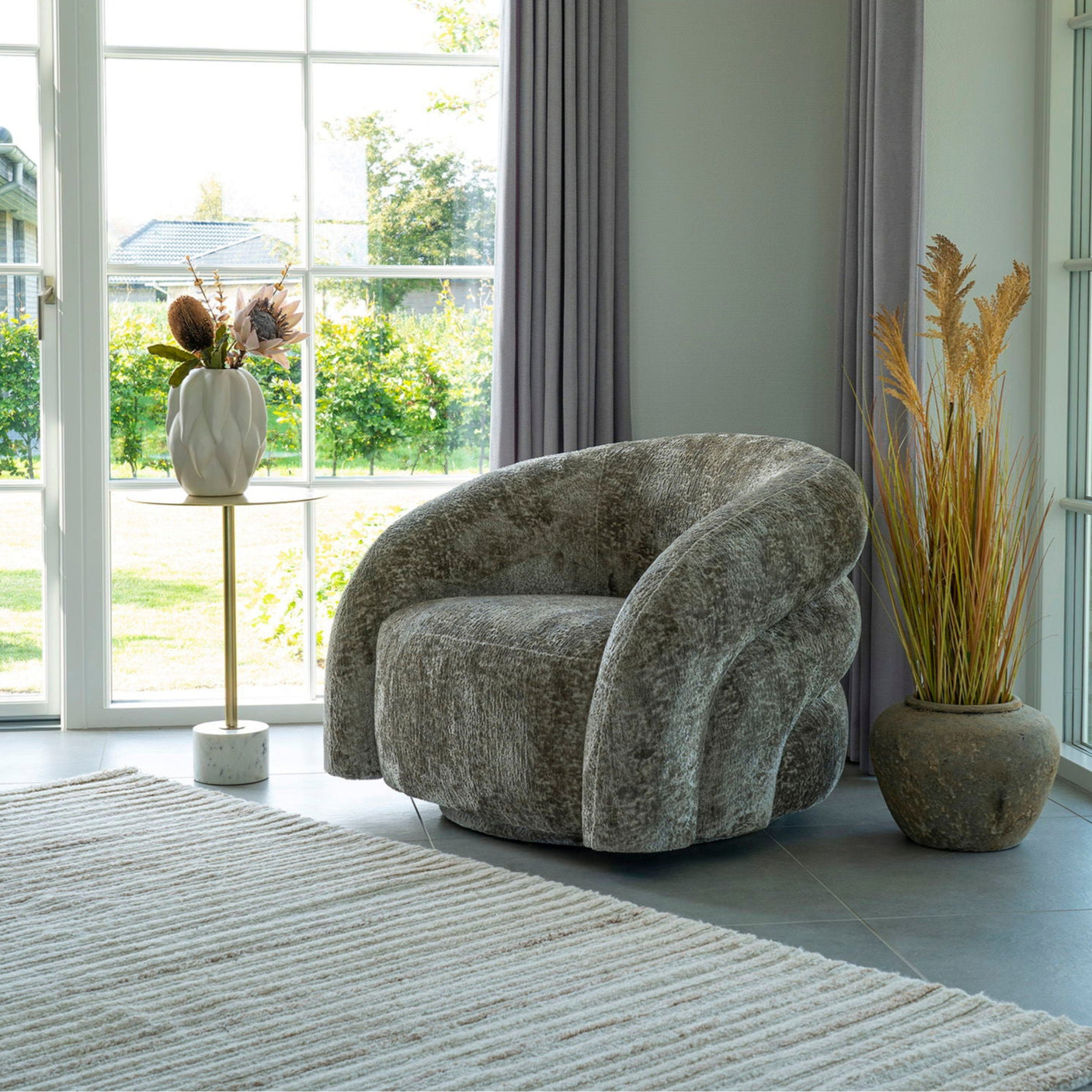 Valletta lenestol fra House Nordic plassert i stue med store vinduer – stilfull og komfortabel loungestol.