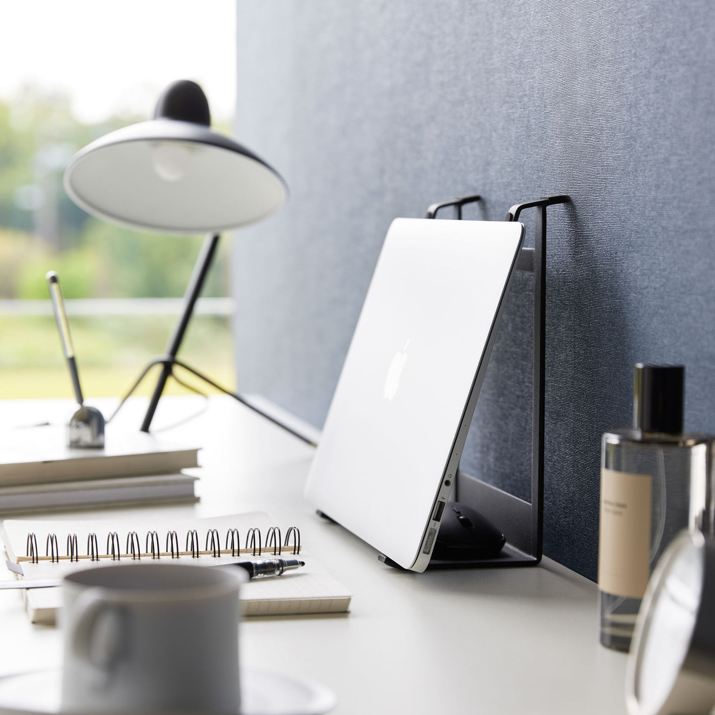 Ergonomisk stativ i sort metall brukt til både laptop og nettbrett.