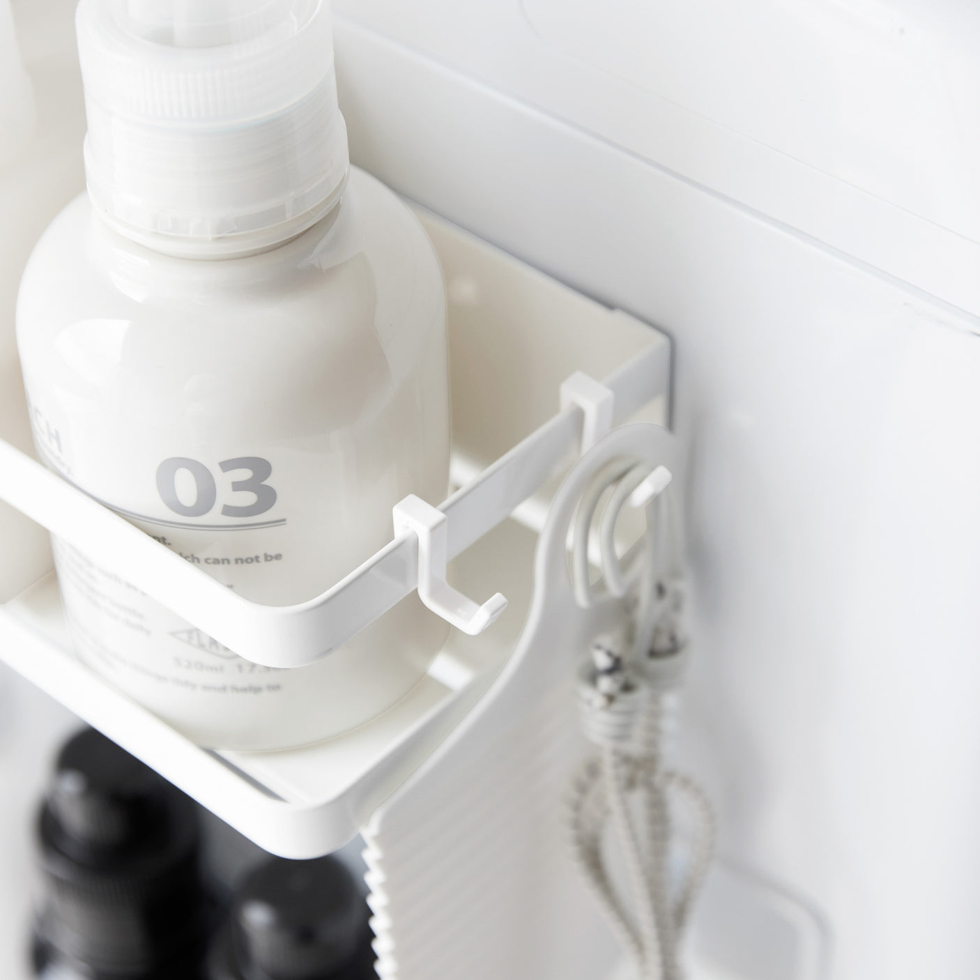 Toetasjes hvit metallhylle brukt til oppbevaring på vaskerom.