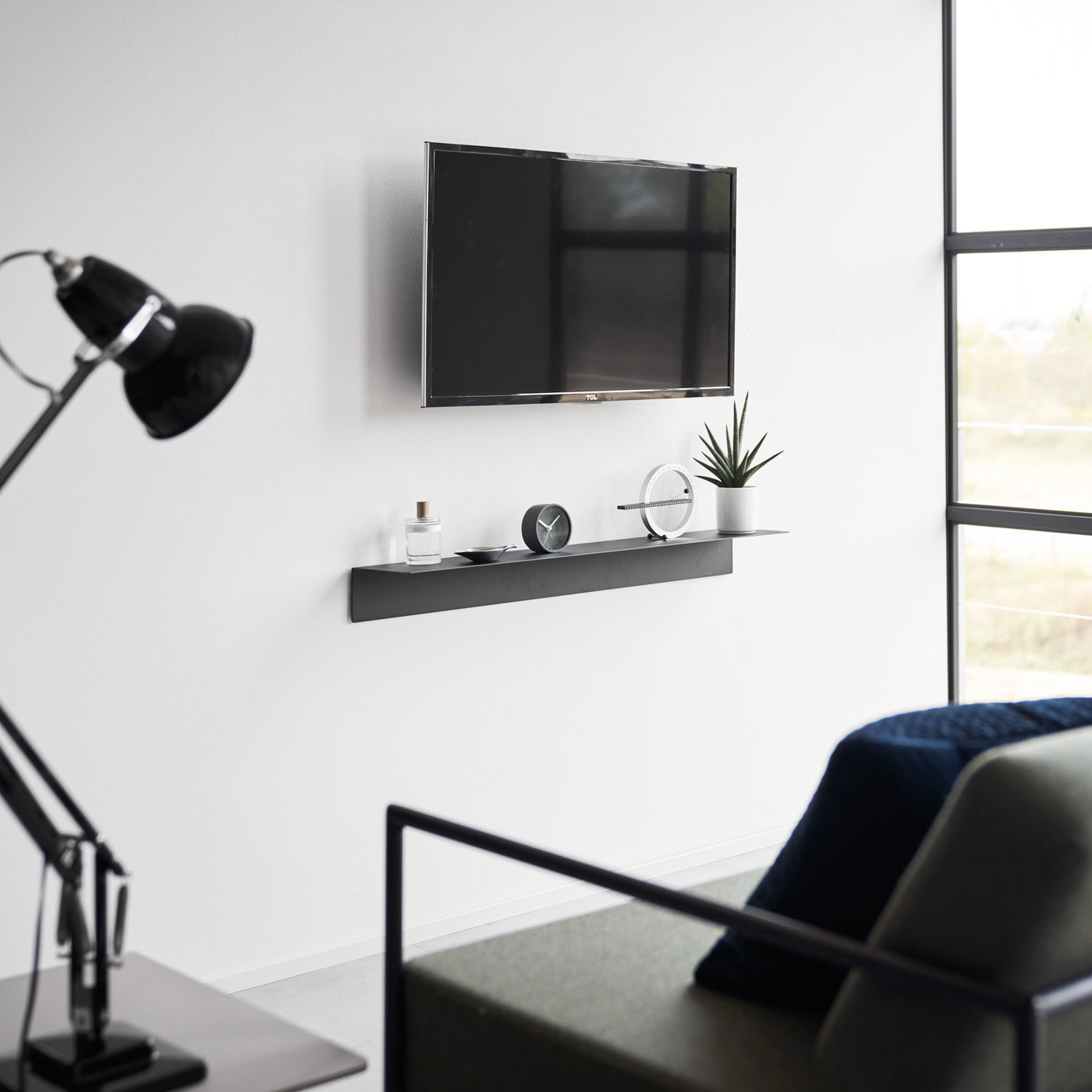 Svevende sorte hyller i moderne stue med TV