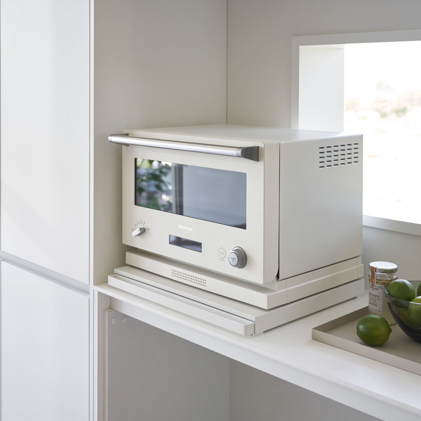 Hvitt kjøkken med uttrekkbar hylleplate under mikrobølgeovn