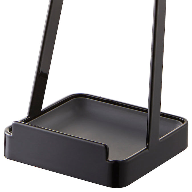 Detaljbilde av sort kjøkkenstativ i metall, designet for lokk og sleiver.