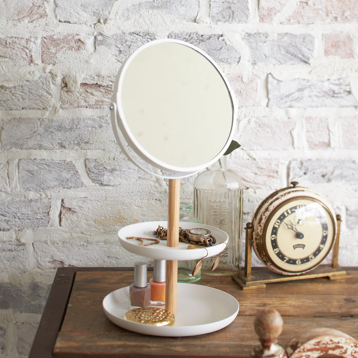 Justerbart speil på et smykkebrett med smykker og tilbehør rundt.