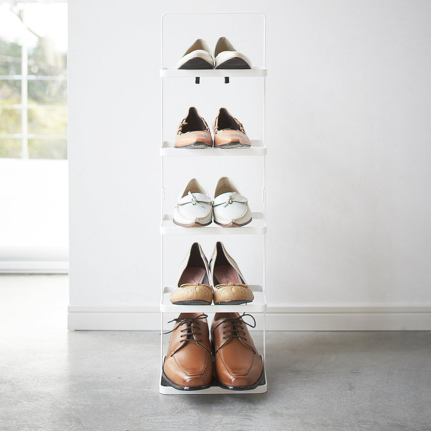 Minimalistisk skohylle i hvitt metall, perfekt for smart oppbevaring i små rom.