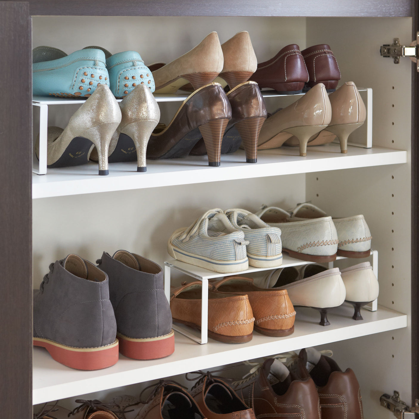 Skohylle i stål plassert i garderobe med flere par sko