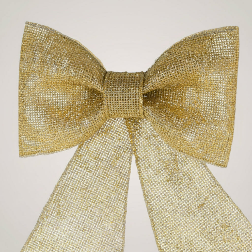 Nærbilde av gullfarget juletresløyfe med glitter og lange bånd.