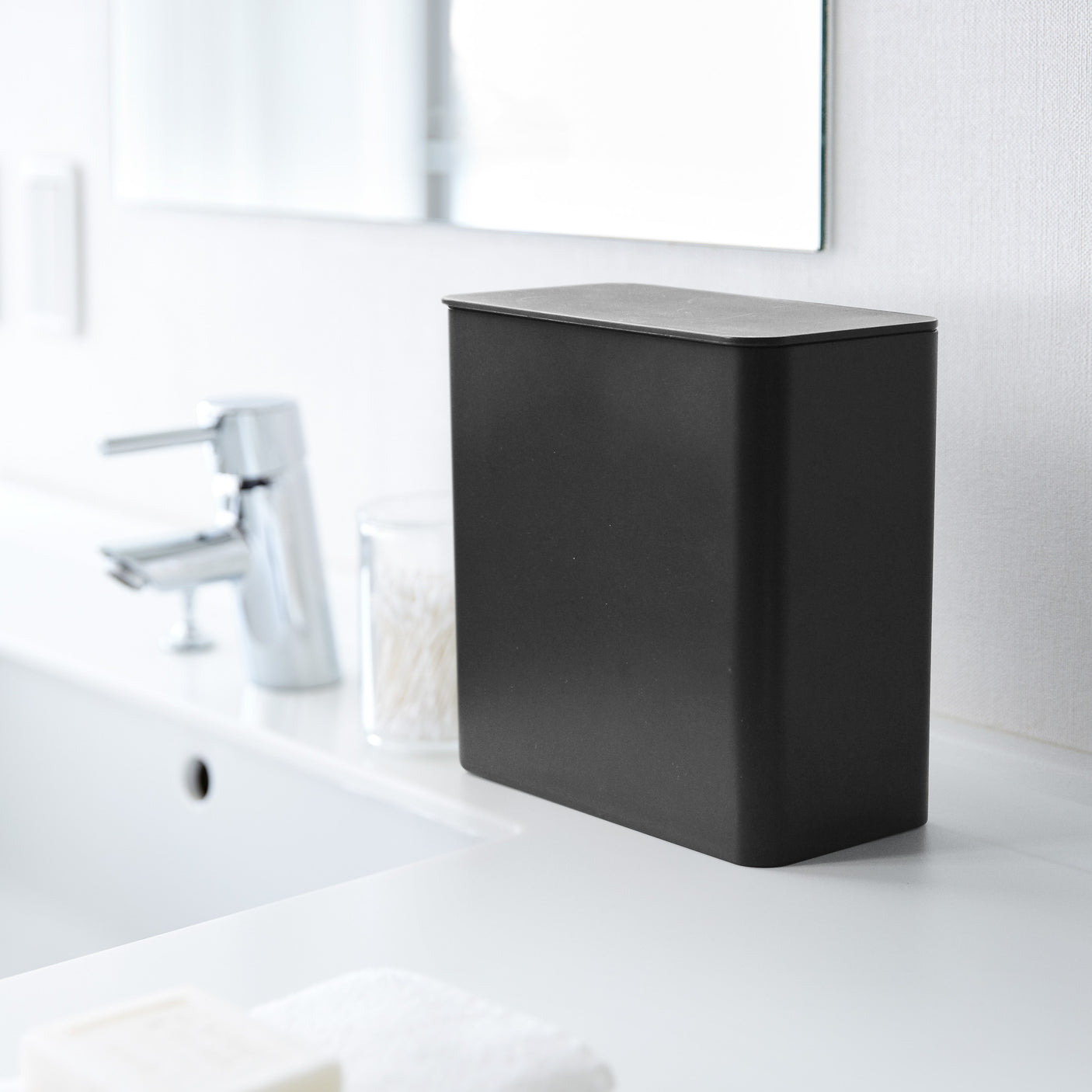 Magnetisk boks i sort plast på vaskerom med vaskemidler.