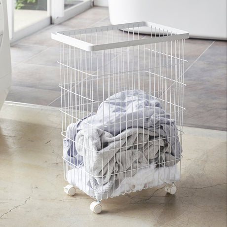 Hvit skittentøyskurv med hjul for enkel forflytning.