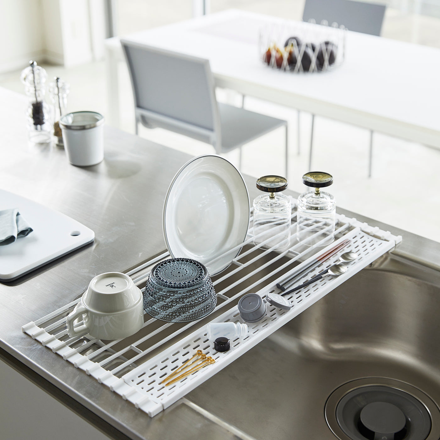 Sammenleggbar oppvaskrist i hvit metall og silikon.