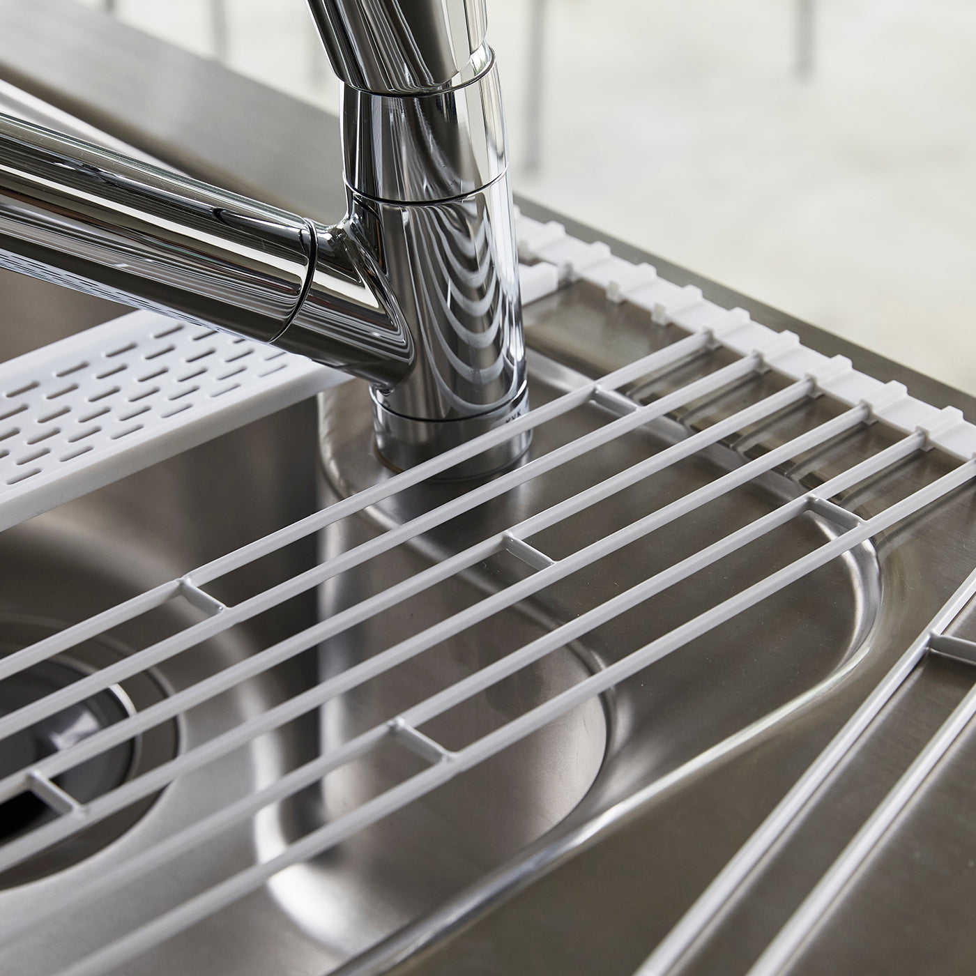 Praktisk og sammenrullbar oppvaskrist i hvit farge.