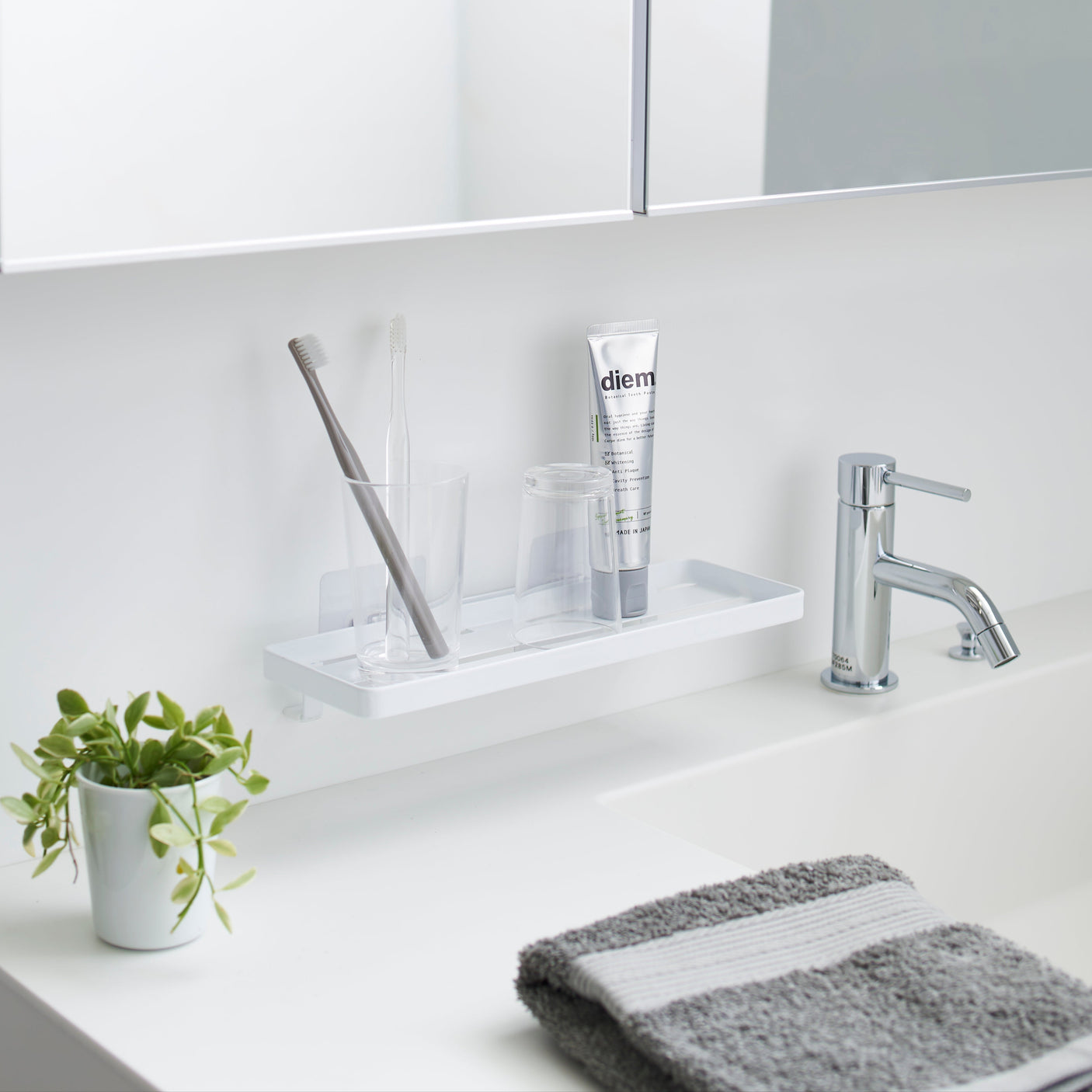 Hvit baderomshylle med sugekopper for enkel montering.