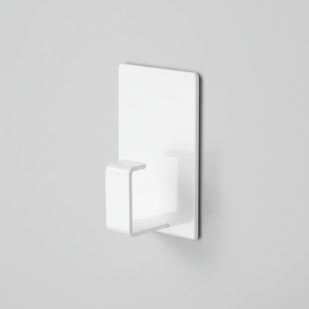 Hvit magnetisk krok montert på vaskemaskin med skittentøyskurv.