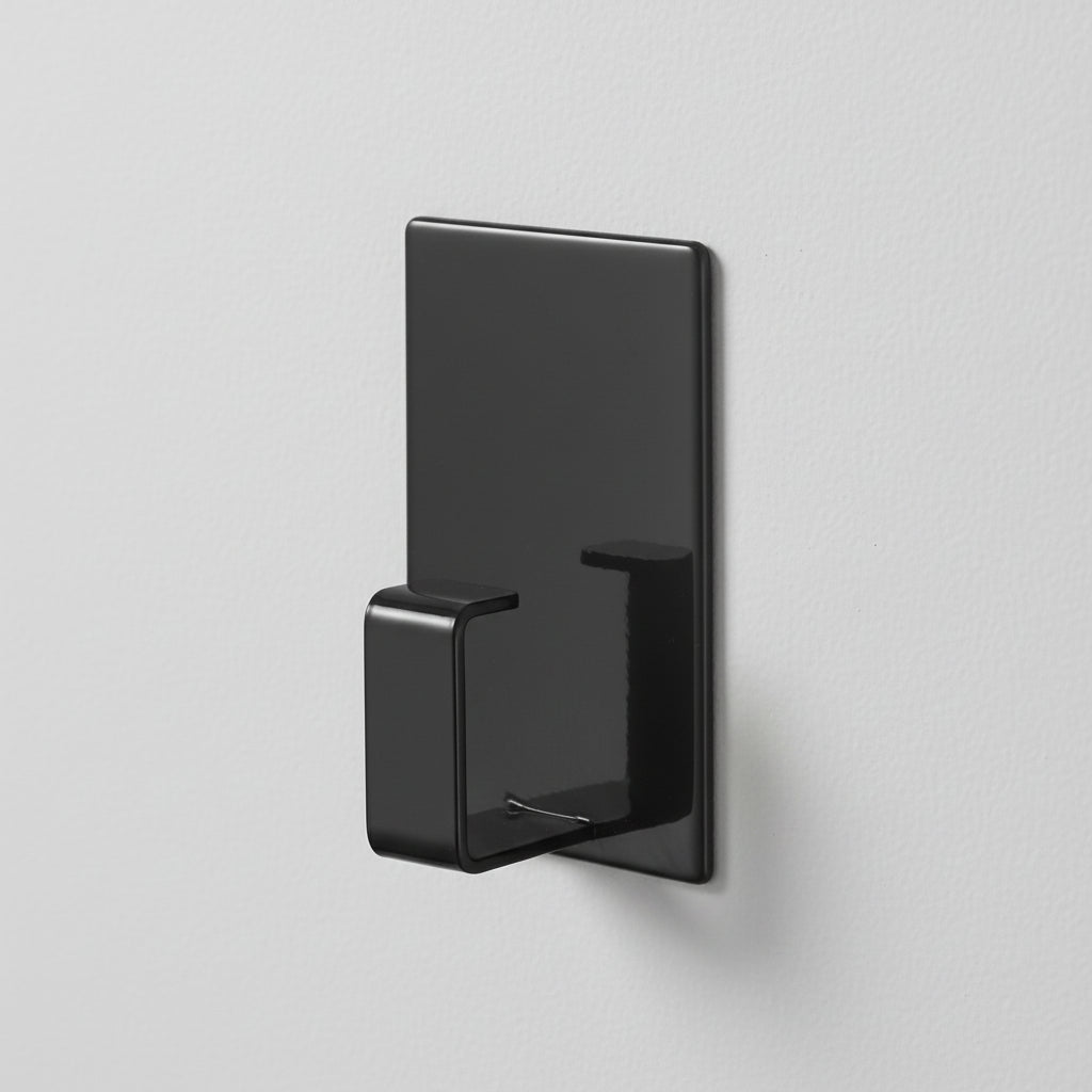 Sort magnetisk opphengskrok festet på vaskemaskin.