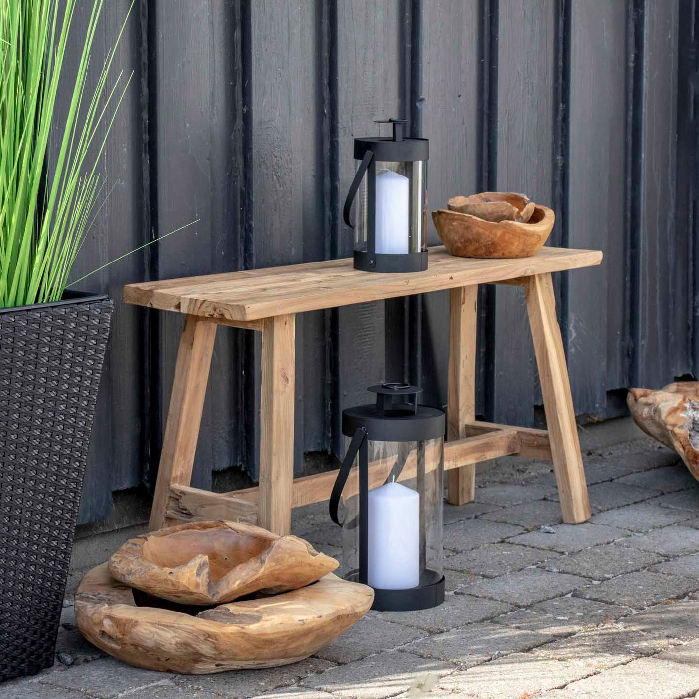 Sort lanterne på terrasse ved trebenk