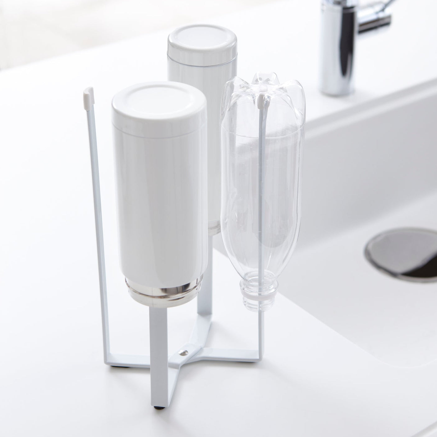 Hvit flerbruksstativ for tørking av flasker og kjøkkenutstyr.