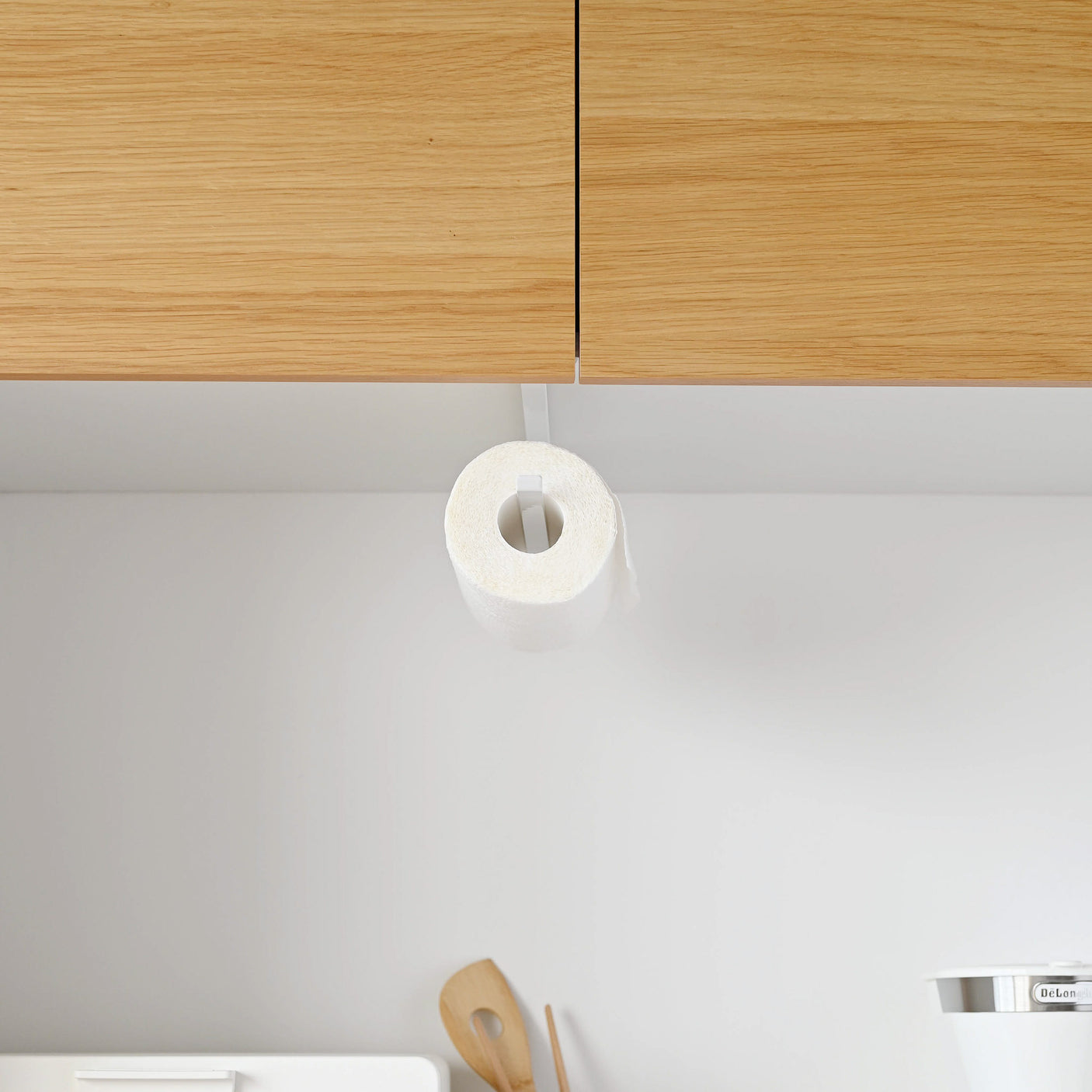 Tørkepapirstativ under kjøkkenhylle med minimalistisk design