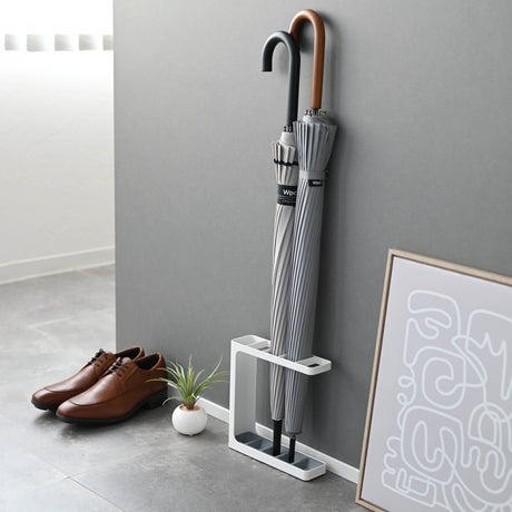 Lite paraplystativ i hvitt med plass til flere paraplyer – perfekt for små ganger.