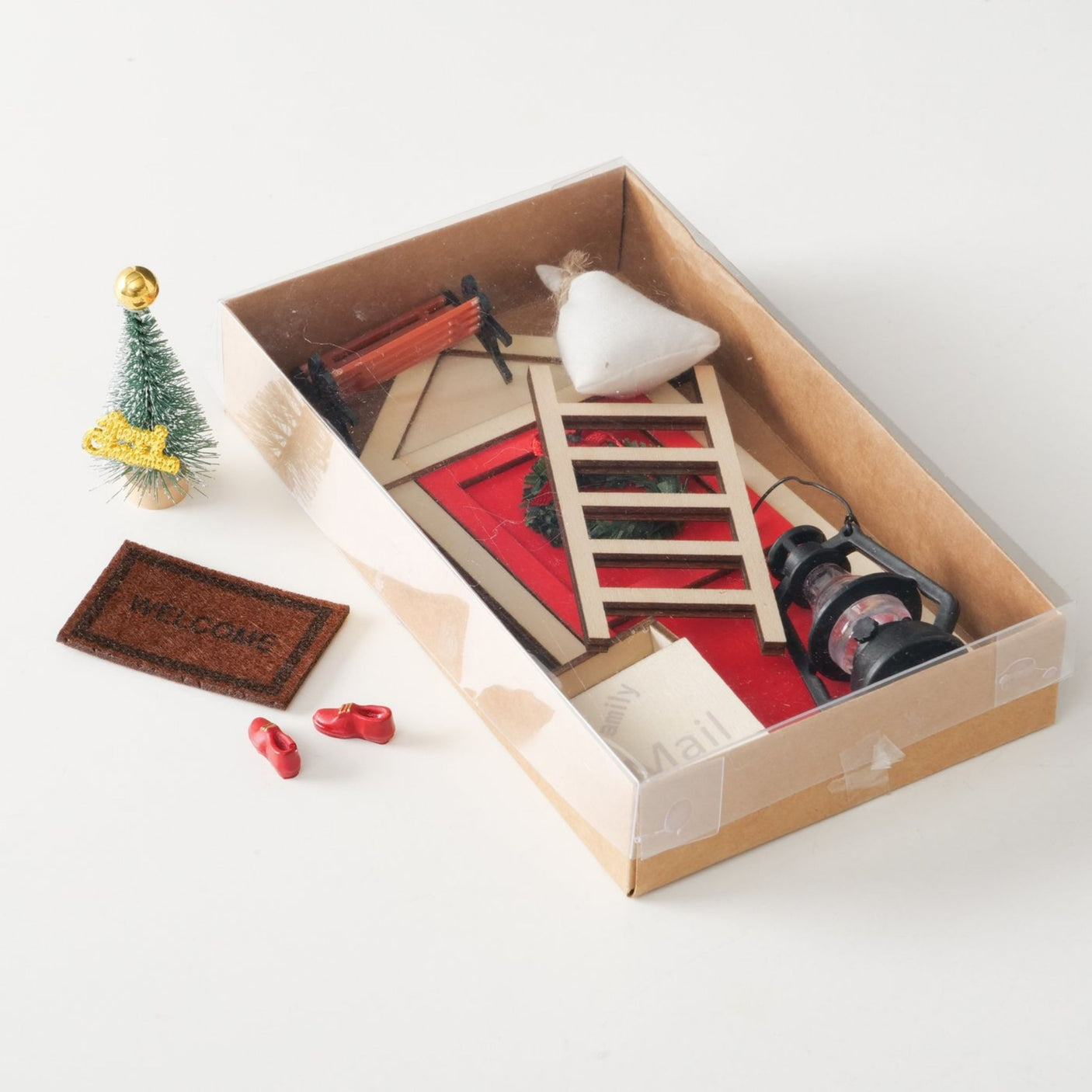 Uåpnet miniatyrsett i eske med noen deler liggende utenfor.