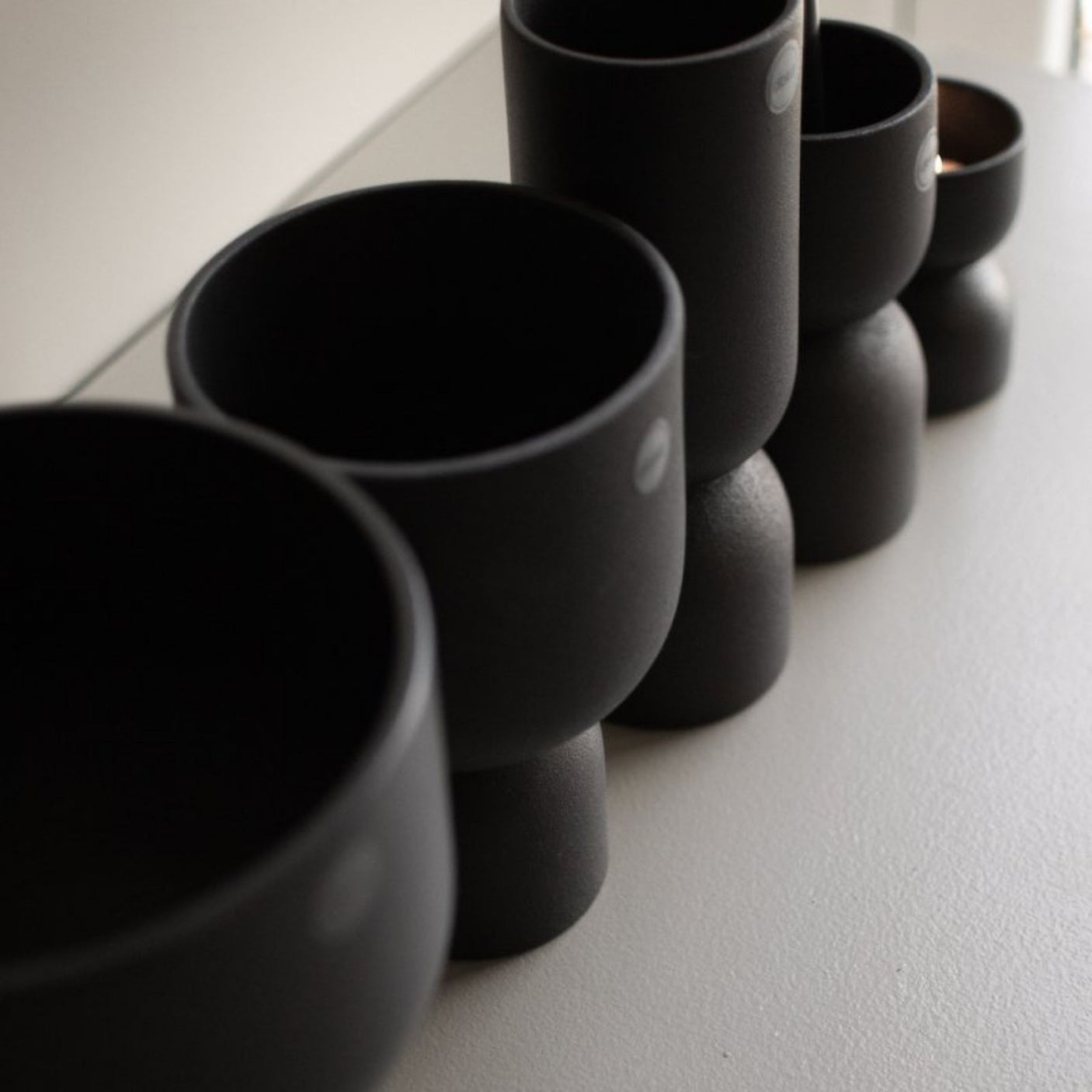 DBKD Post potter sort i ulike størrelser arrangert sammen på bord – Lindas Dekor