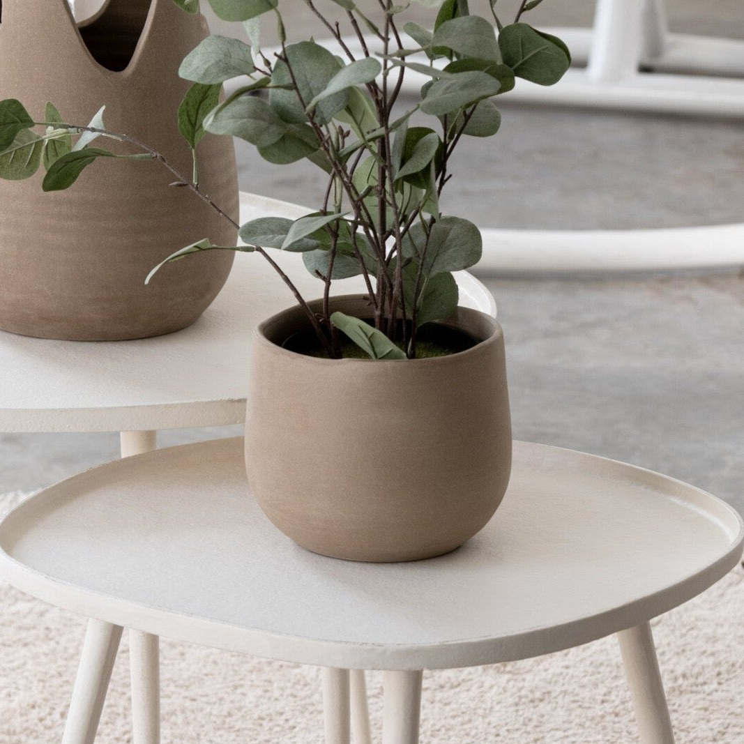 Sandy beige potte med brent, keramisk finish, plassert på et lyst sidebord i moderne interiør. Dekorativ og tidløs blomsterpotte som passer perfekt til både kunstige og ekte planter. Ideell for stue, kjøkken eller kontor.