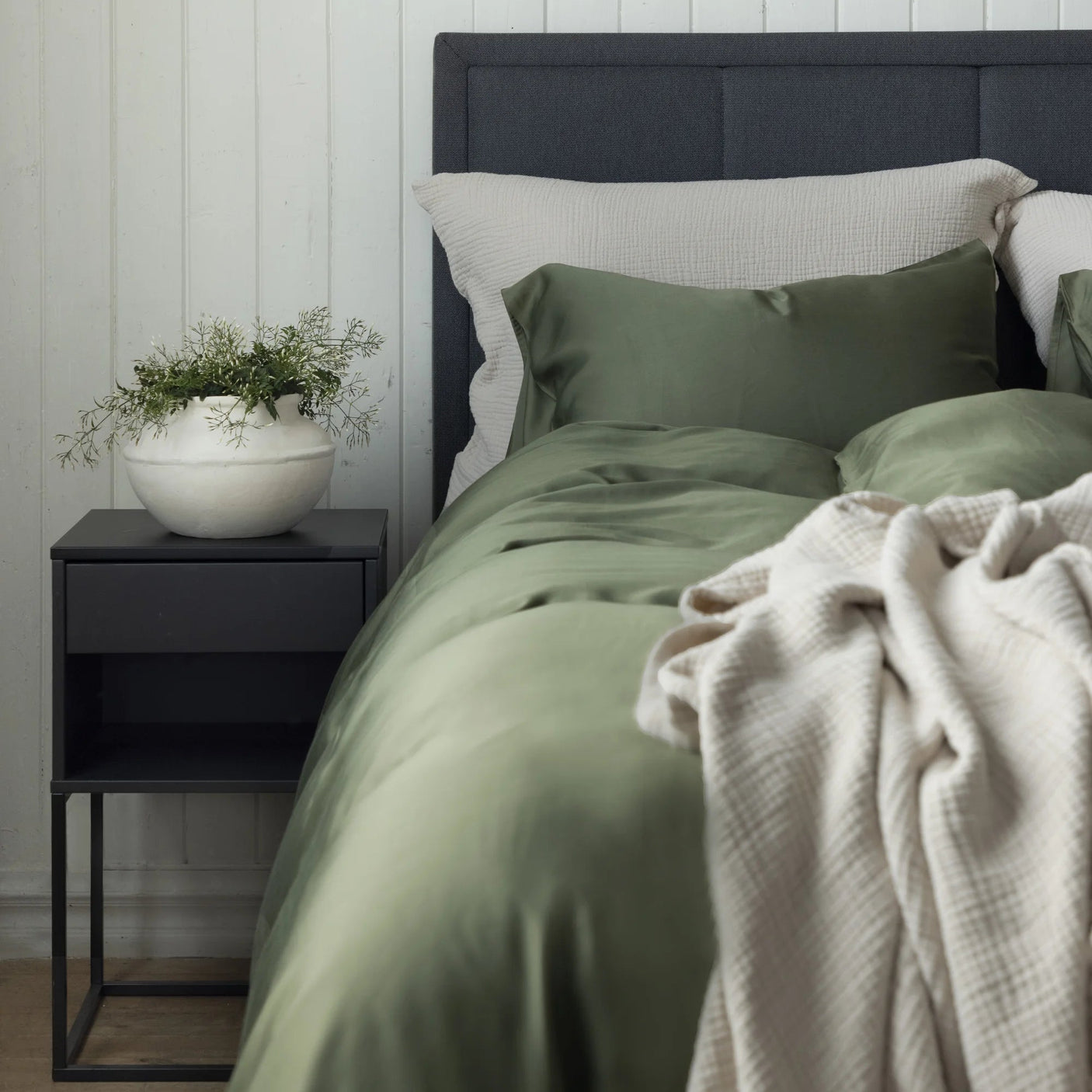 Grønt Borås Cotton Bliss sengesett på oppredd seng med beige pledd