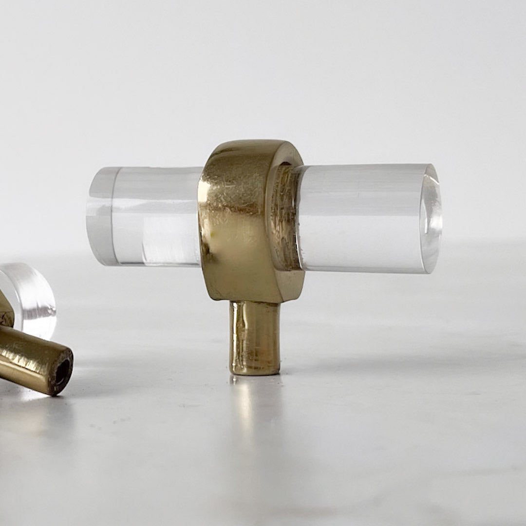 Nesu T-bar knott i glass og messing stående på lys overflate.