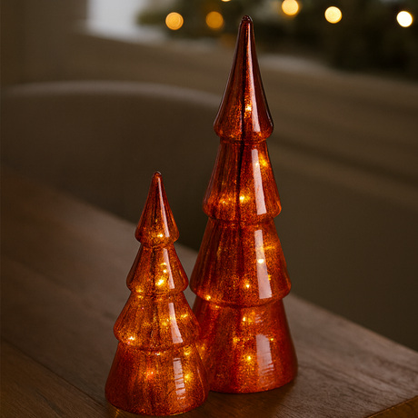 Røde glassjuletrær med LED-lys som lyser varmt