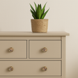 Knotter i børstet messing med marketeri mønster montert på beige kommode. Stilfull detalj som gir et eksklusivt og personlig preg til oppbevaringsmøbler i hjemmet.