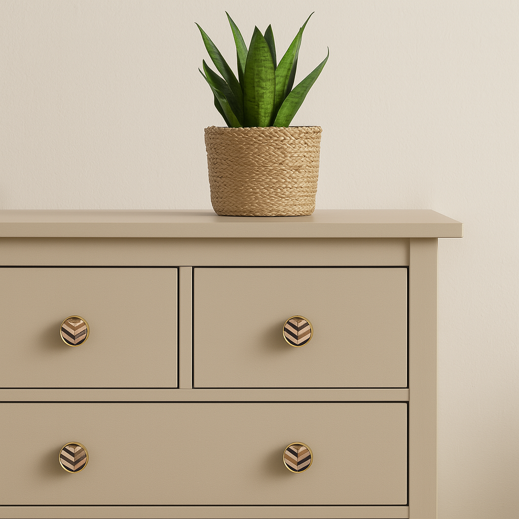 Knotter i børstet messing med marketeri mønster montert på beige kommode. Stilfull detalj som gir et eksklusivt og personlig preg til oppbevaringsmøbler i hjemmet.