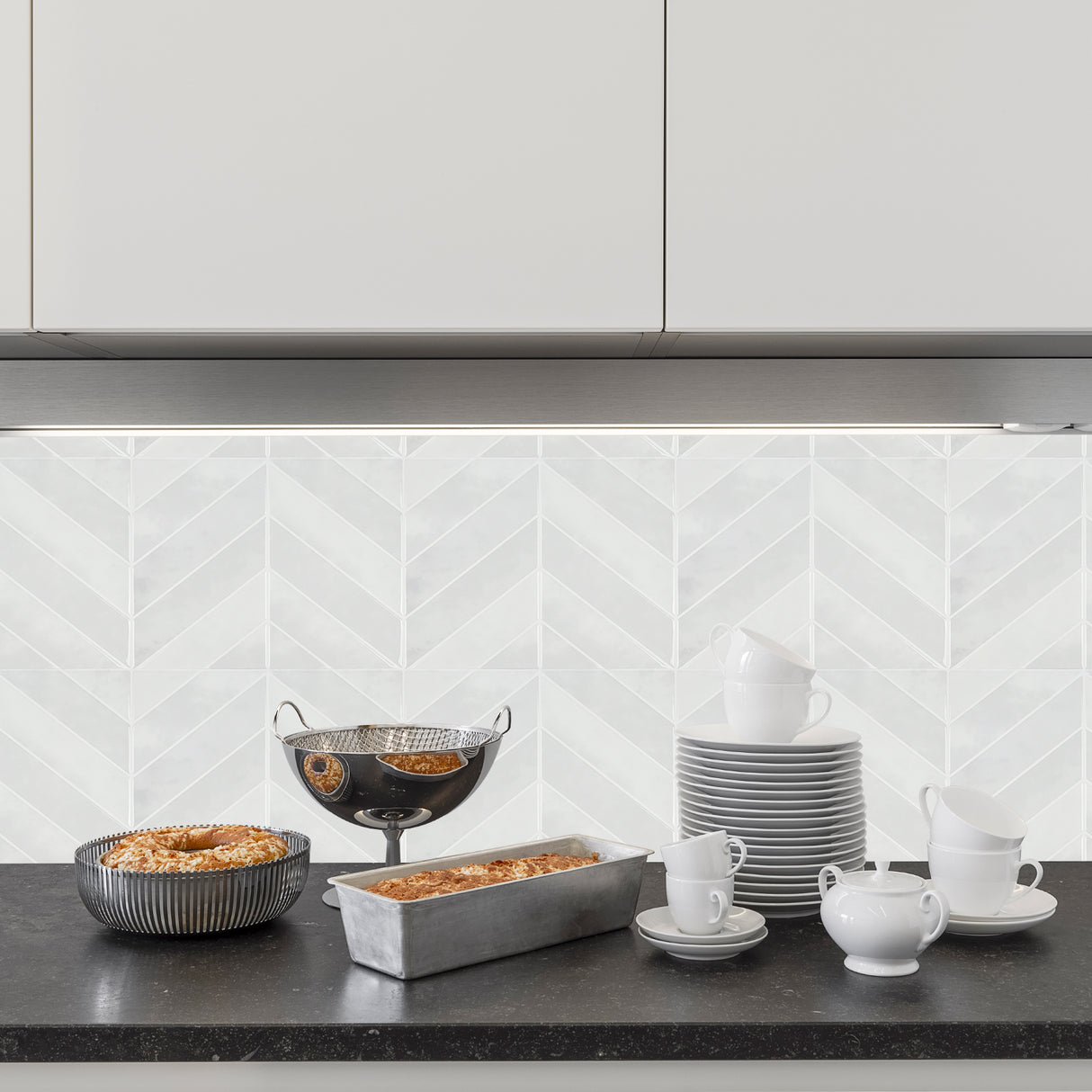 Evelina hvit selvklebende veggflis med elegant fiskebeinsmønster i lyse nyanser.