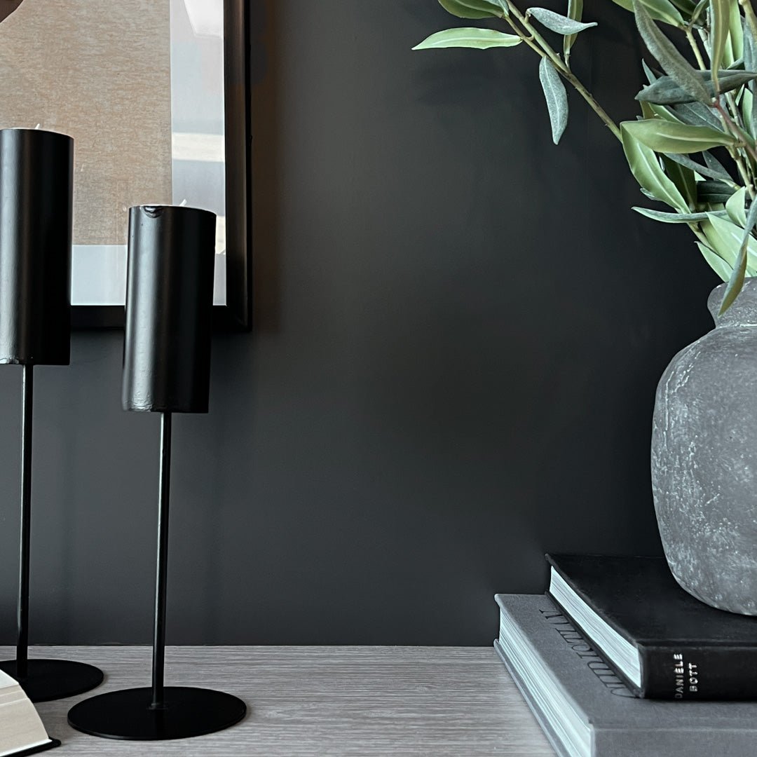 Matt sort selvklebende folie på vegg bak sort lampe og dekorativ vase