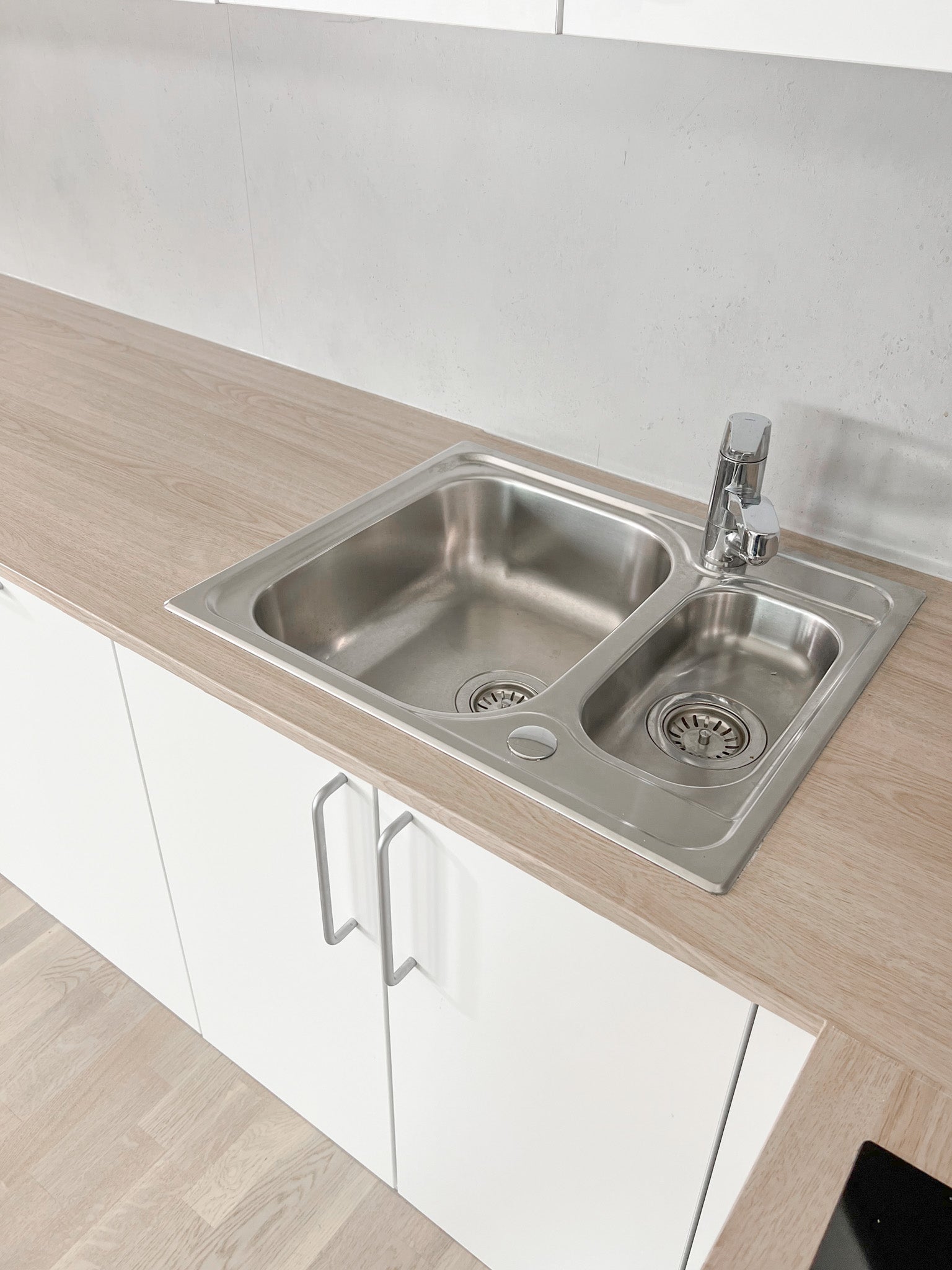 Kjøkkenbenk fornyet med lys eik kontaktplast – slitesterk dekorfolie som gir benkeplaten et naturlig treverkpreg rundt vask og arbeidsflate.