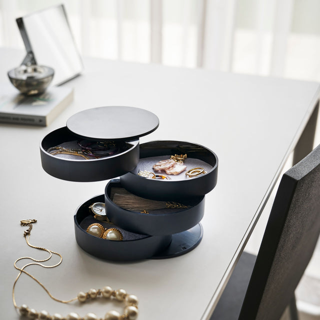 Elegant smykkeboks med svingbar design og mykt fôr for beskyttelse.