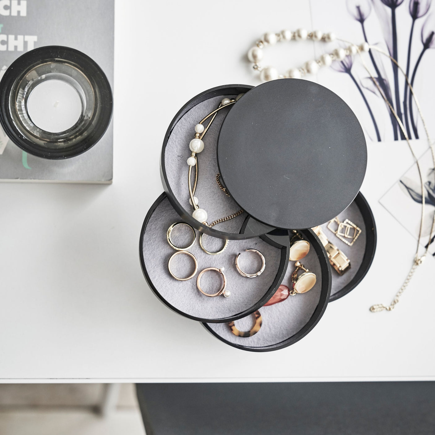 Minimalistisk og funksjonell smykkeboks i sort farge med roterende skuffer.