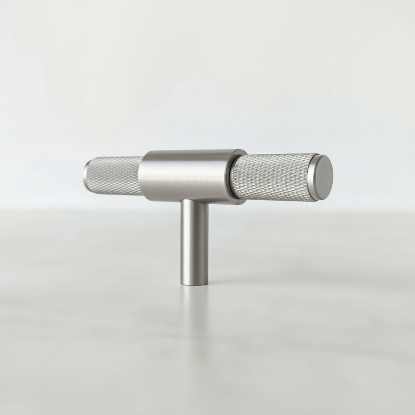 Kvadratisk bilde av minimalistisk T-bar håndtak i sølv på sort møbel