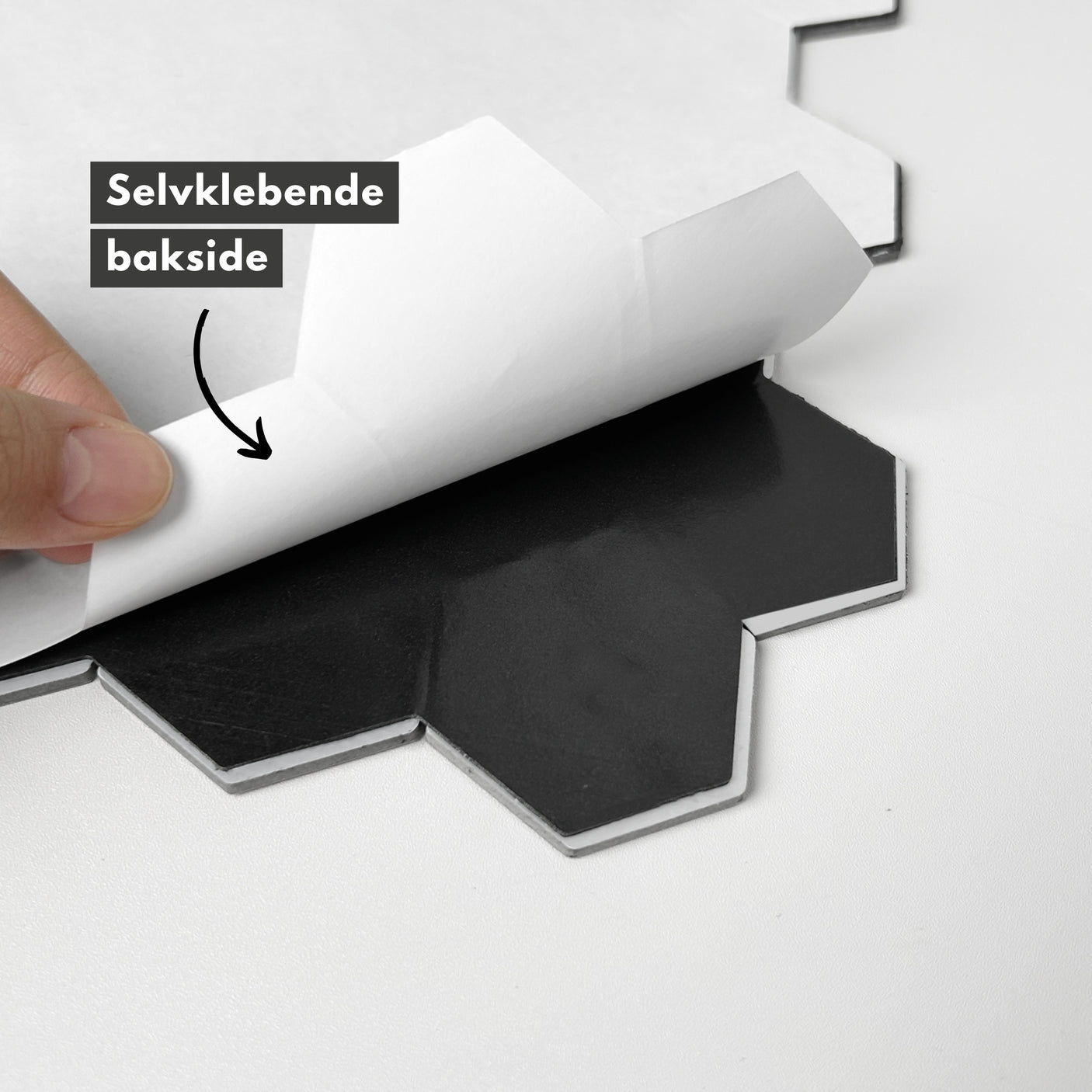 Bakside av latte hexagon flis med selvklebende lag som fjernes ved montering.