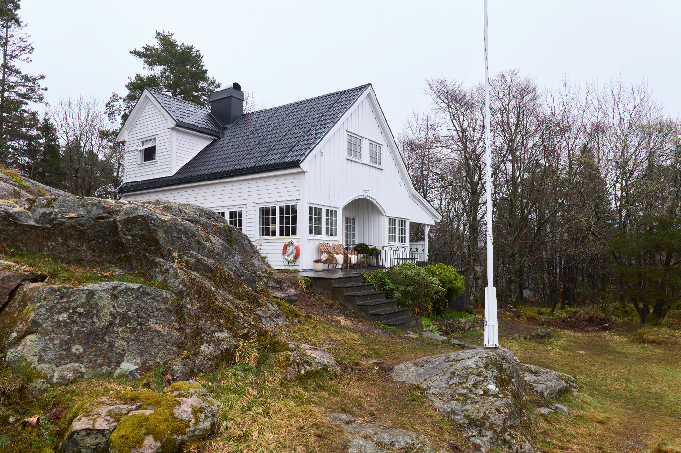 Sykepleierhytten “Odden” i Alvøen utenfor Bergen, brukt i Eventyrlig Oppussing. En klassisk hvitmalt hytte omgitt av berg og natur.