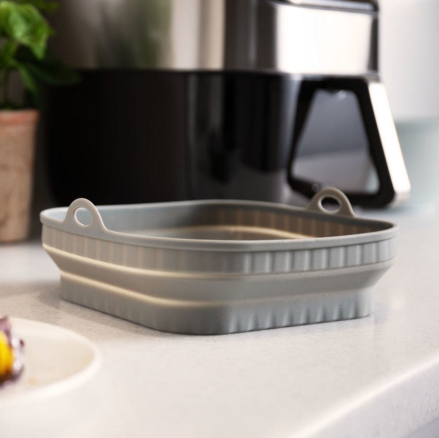 Grå airfryer-insats med luftcirkulerande riljemönster