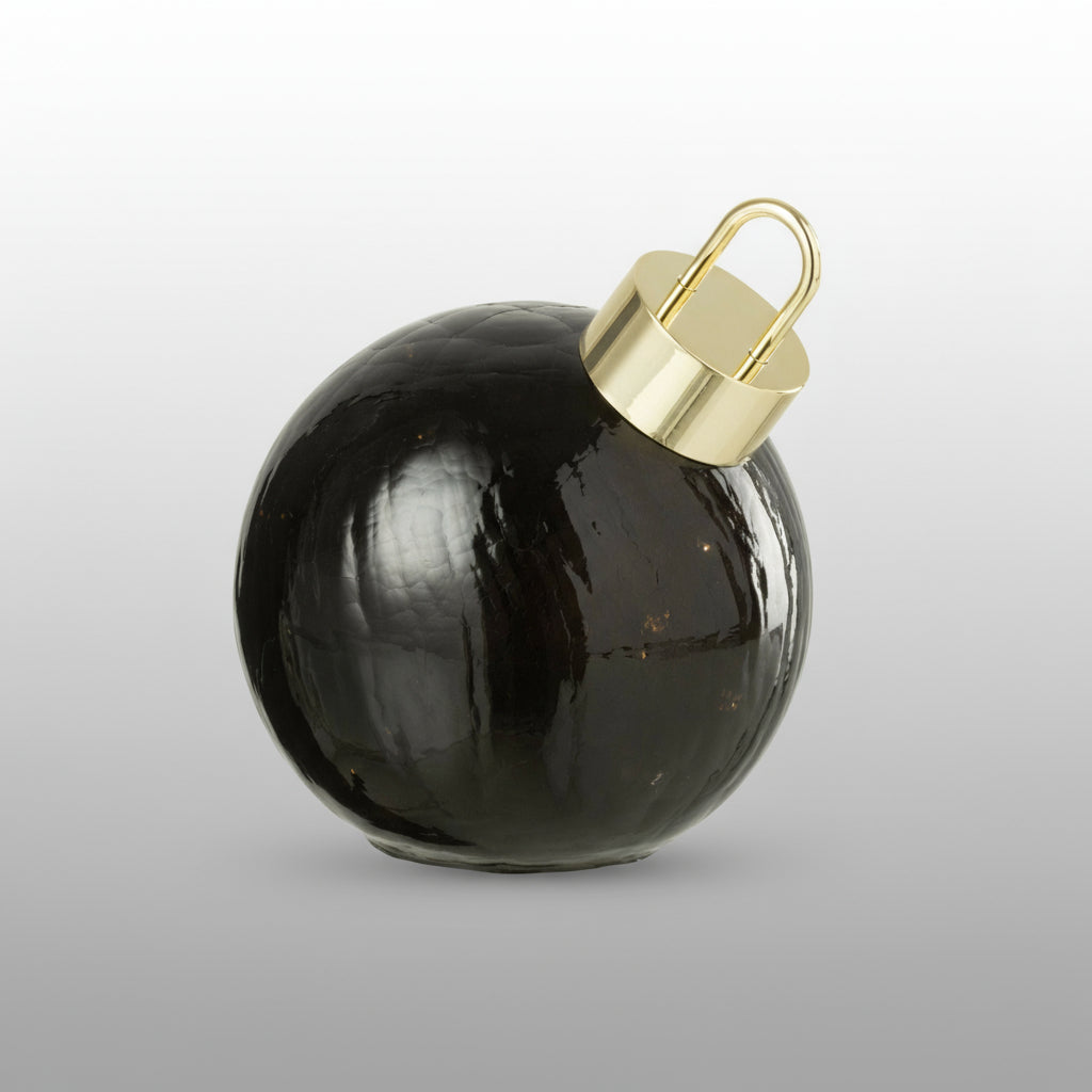 Julekule i svart glass med LED-lys på hvit bakgrunn.