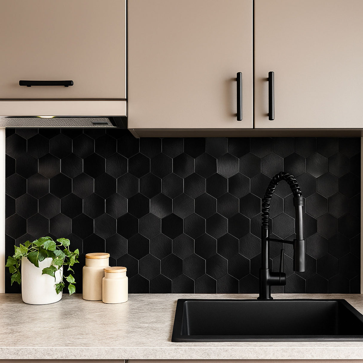 Moderne kjøkken med svarte sekskantede selvklebende fliser, svart kjøkkenkran, beige skap og benkeplate i lys betonglook med dekor.