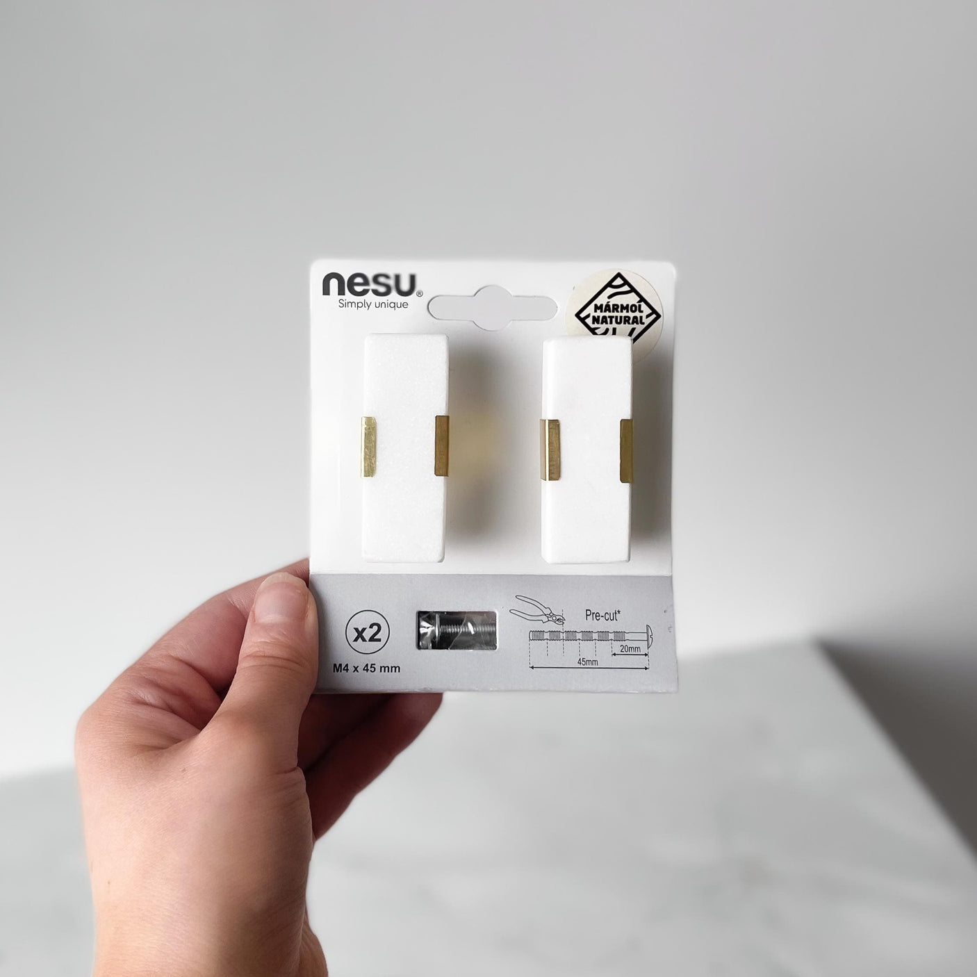 Designhåndtak med naturlig marmor og skinnende messingdetaljer.