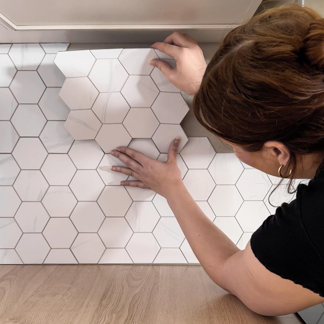 Kjøkkenvegg fornyet med elegante hexagonfliser i marmorstil.