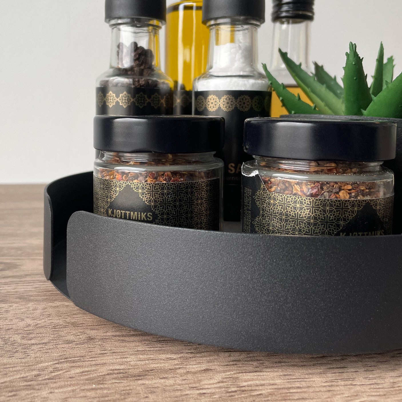 Stilrent snurrebrett med krydderglass – perfekt for å holde krydder og oljer samlet på kjøkkenbenken og skape et ryddig uttrykk.