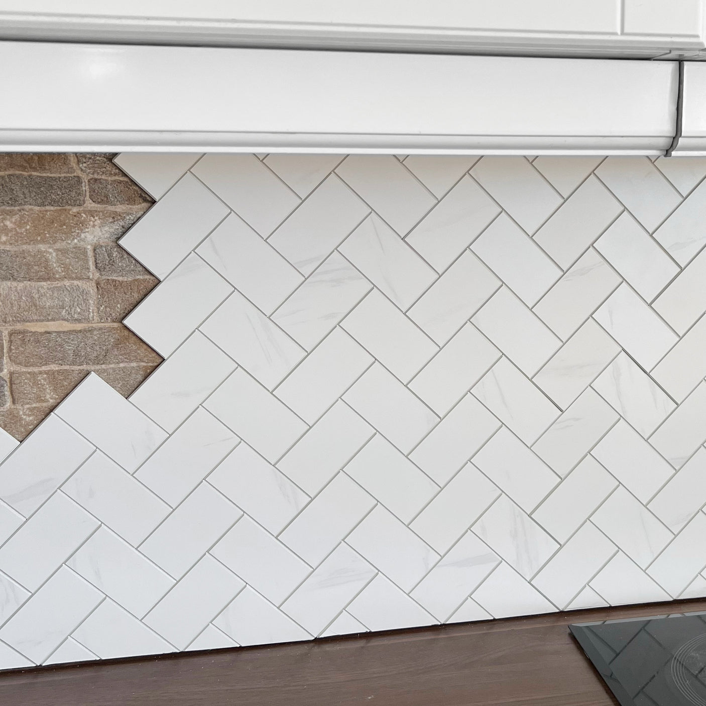 Stein fiskebein marmor veggfliser montert i klassisk fiskebeinsmønster.