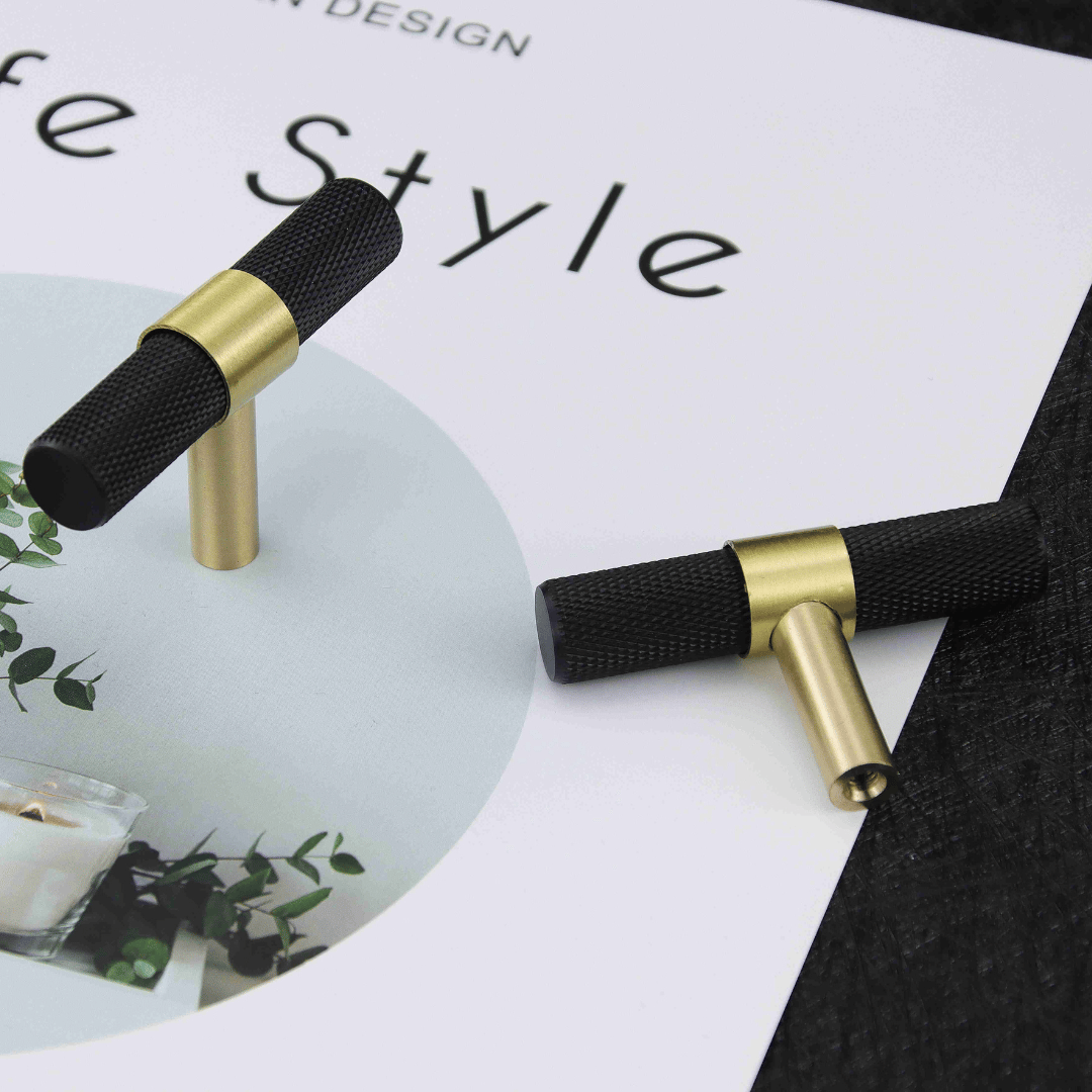 Sorte og messingfargede T-bar håndtak lagt på et magasin med plantebilde.