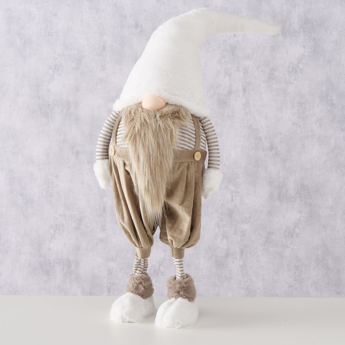 Helfigur av julefigur-nisse med hvit hatt, brunt skjegg og brune selebukser.