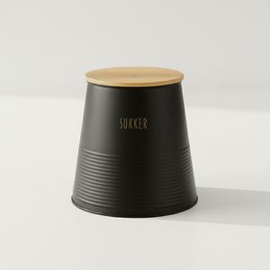 Kvadratisk bilde av sort sukkerboks med bambuslokk og silikonring plassert på kjøkkenbenk i nordisk stil