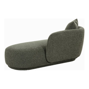 Daybed i grønn tekstil med avrundet form og komfortabel sitteflate.