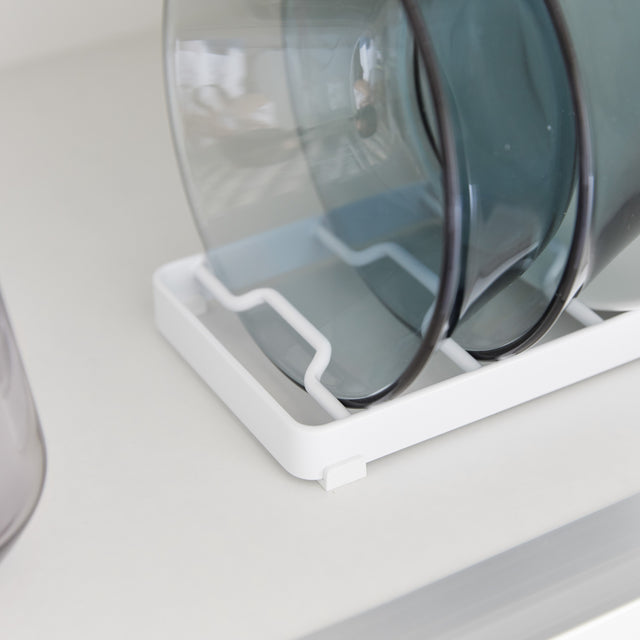 Hvit skålstativ med seks store skåler plassert side om side på kjøkkenbenk.