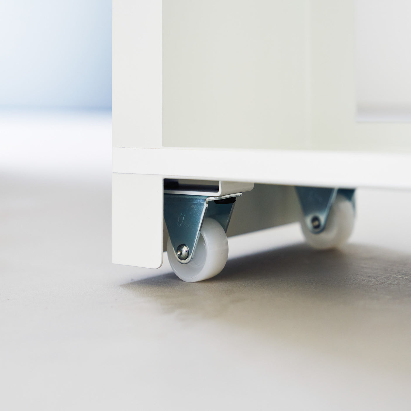 Kompakt baderomsoppbevaring med hjul og to etasjer for papir og rengjøringsmidler.